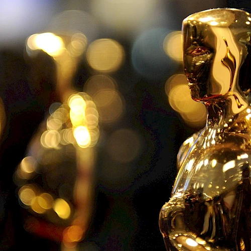 The image shows several golden statuettes, commonly known as Oscars, typically awarded at the Academy Awards for excellence in the film industry.