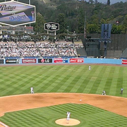 A baseball game is underway at a large stadium with a well-maintained field and packed stands.