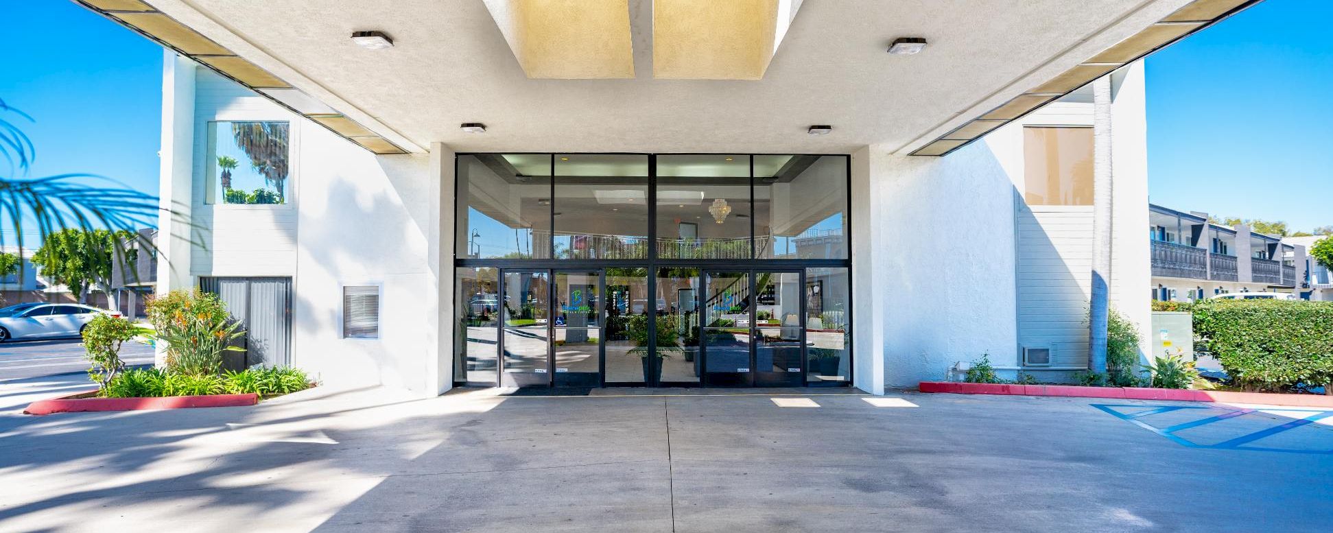 A white building with glass doors and a covered entrance