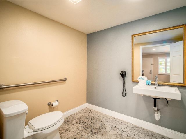 A standard bathroom with a toilet, sink, and mirror.