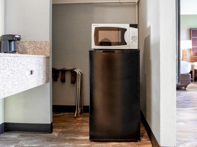 A mini fridge and microwave on a countertop in a hotel room