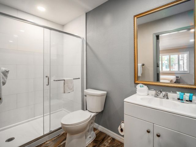 A clean bathroom with a shower, toilet, sink, and mirror